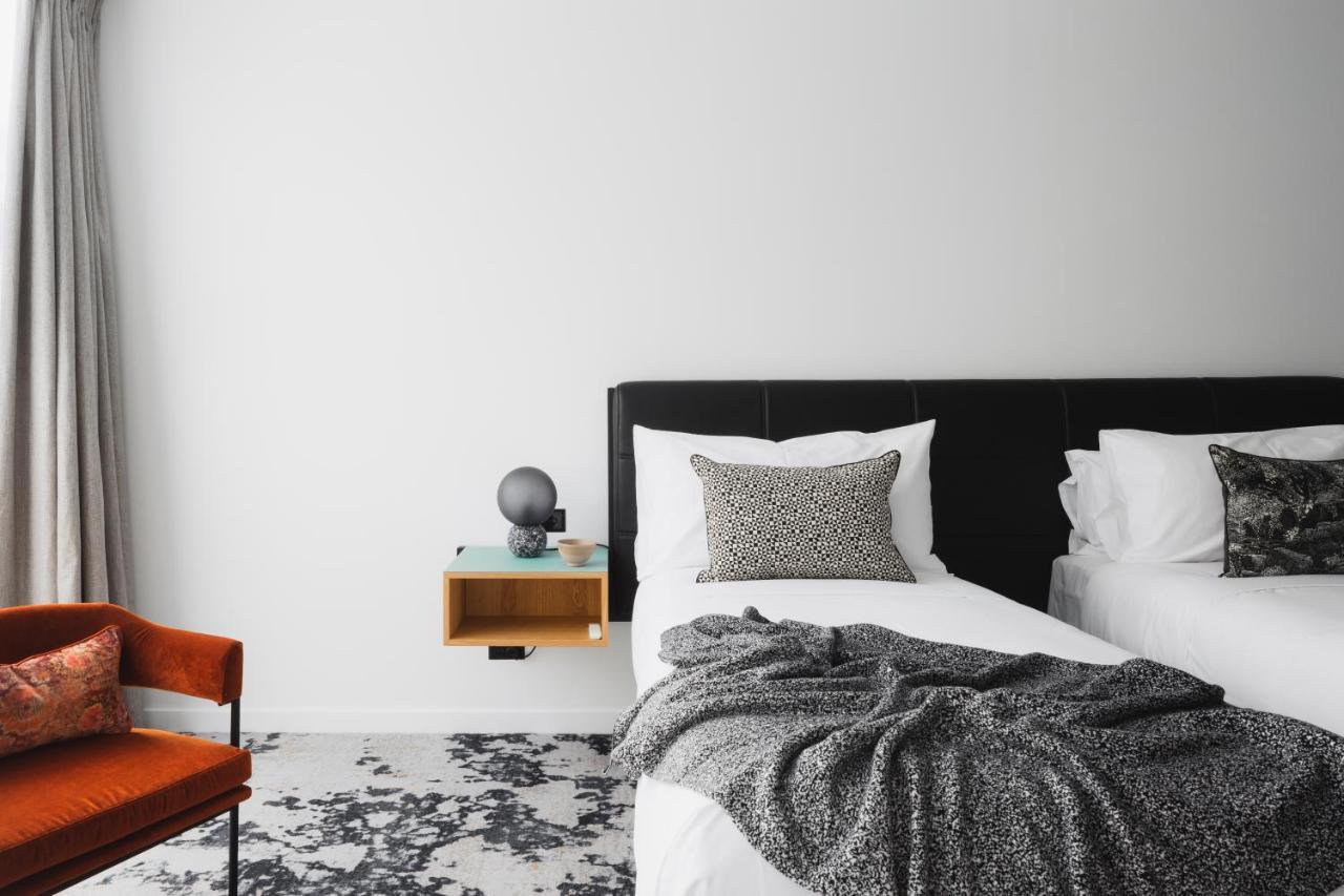 Ebb-ดะนีดิน ภายนอก รูปภาพ A bedroom with a bed, a chair and a nightstand