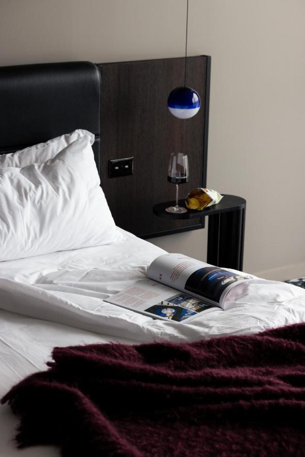 Ebb-ดะนีดิน ภายนอก รูปภาพ A bed with a magazine and a wine bottle